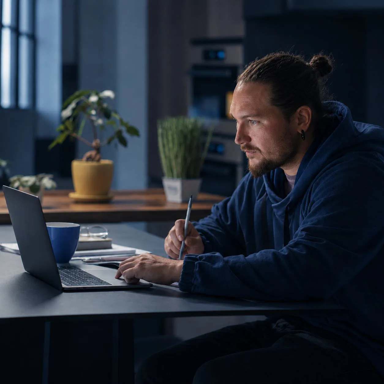 Pessoa trabalhando no notebook, em um escritório à noite